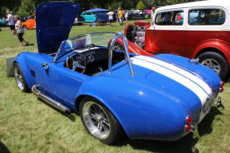 A blue and white sports car with the hood up