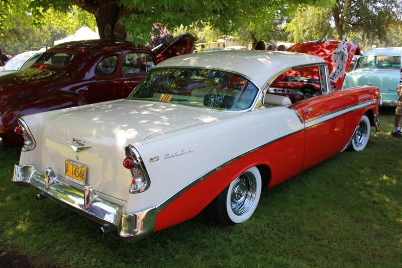 A red and white car is parked in the grass