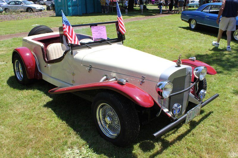 A white and red car with american flags on the windshield