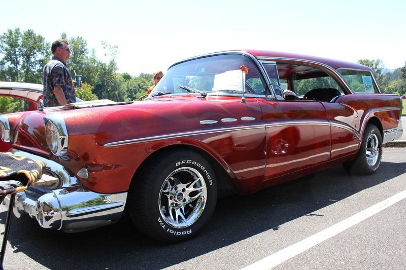 A red buick station wagon is parked in a parking lot