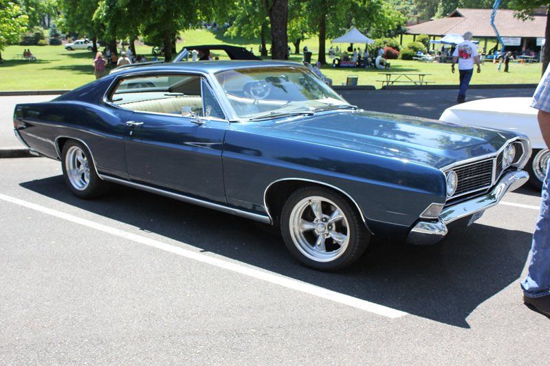 A blue car is parked on the side of the road