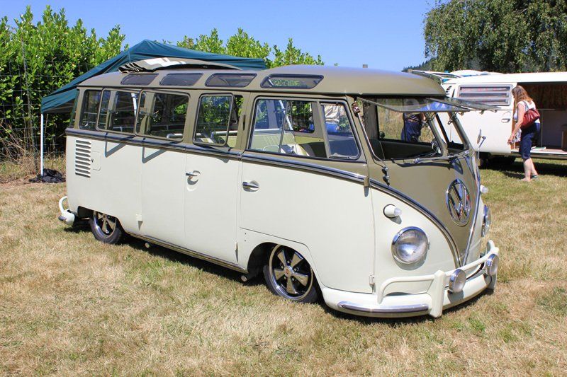 A white van is parked in a grassy field.