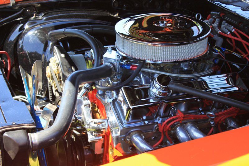 A close up of a car engine with a chrome air filter