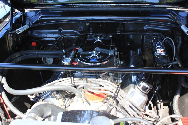 A close up of a car engine with the hood open