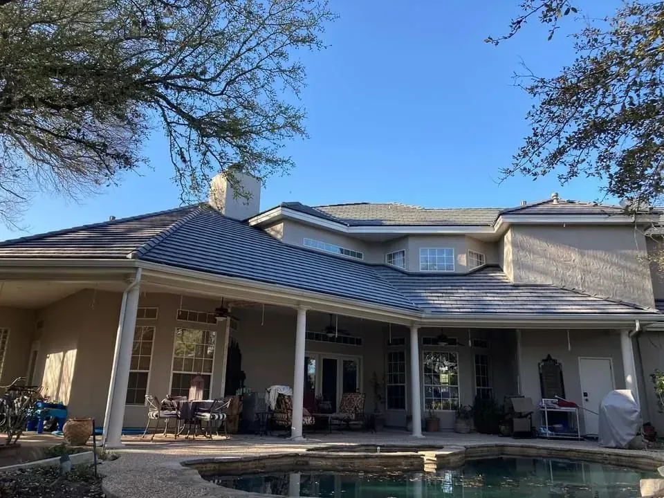 The back of a house with a pool and a covered patio.