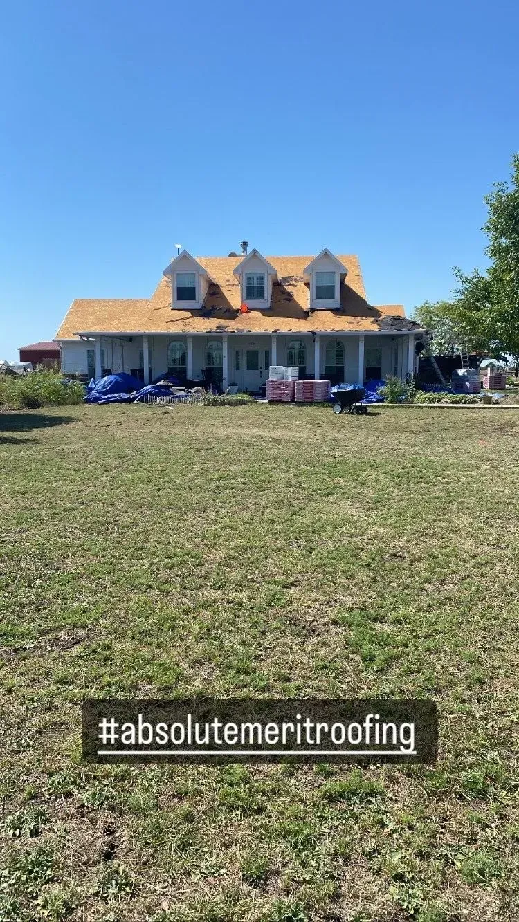 A large house is sitting on top of a lush green field.