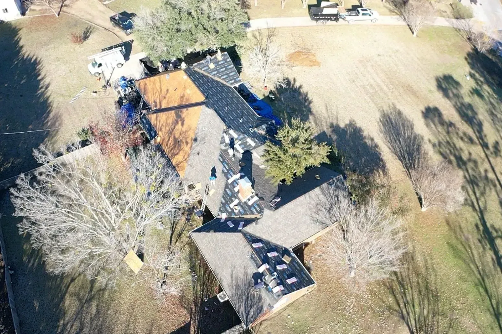An aerial view of a house with a roof that is being repaired.