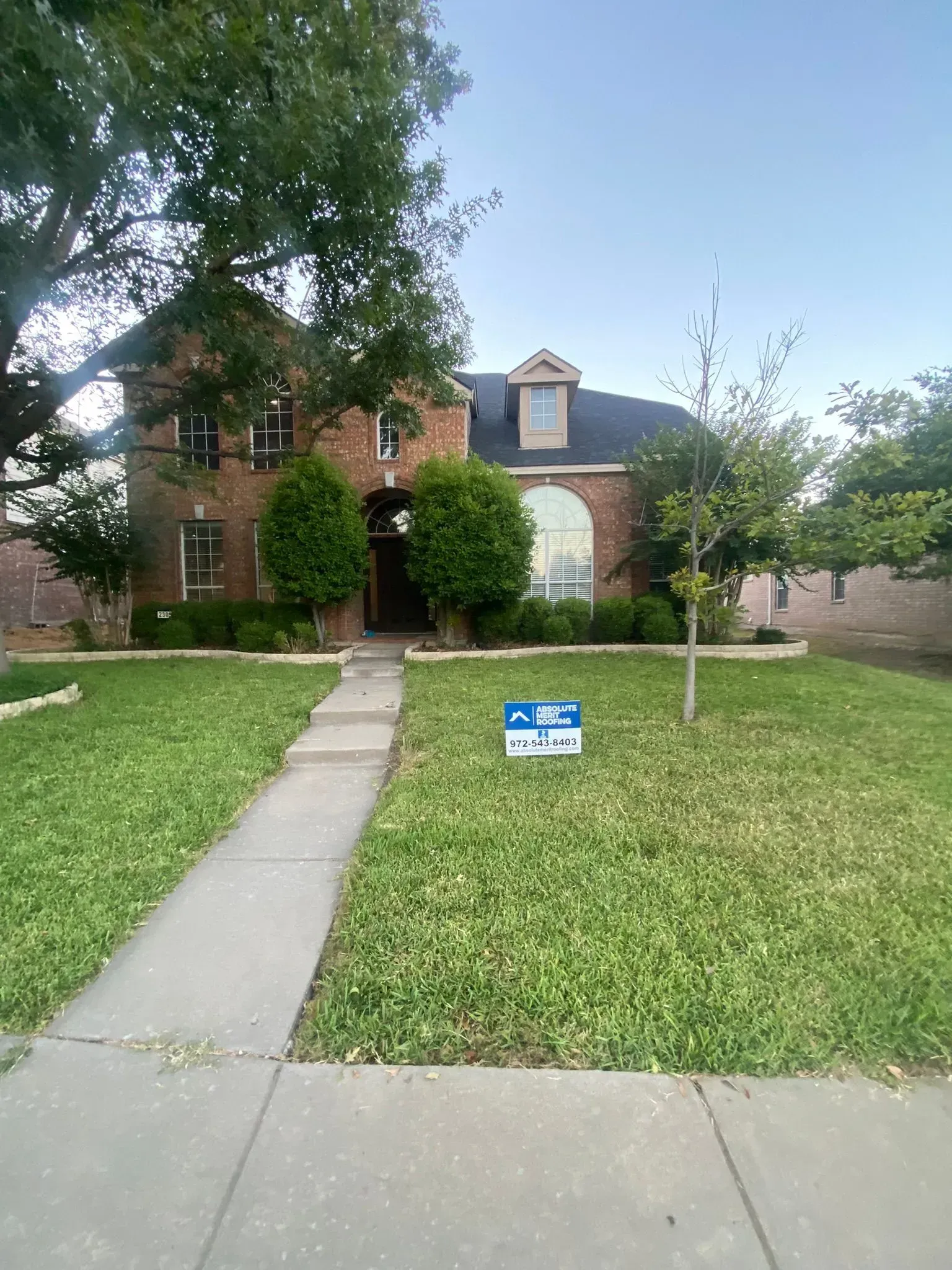 A house with a for sale sign in front of it.