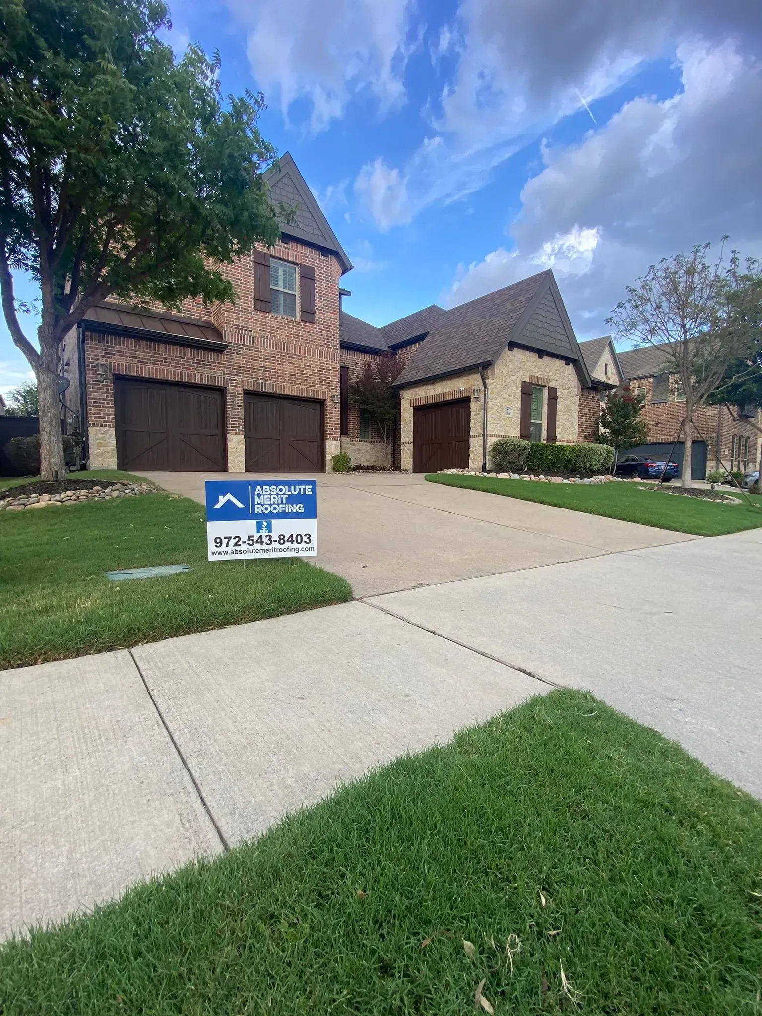 A large brick house with a for sale sign in front of it.