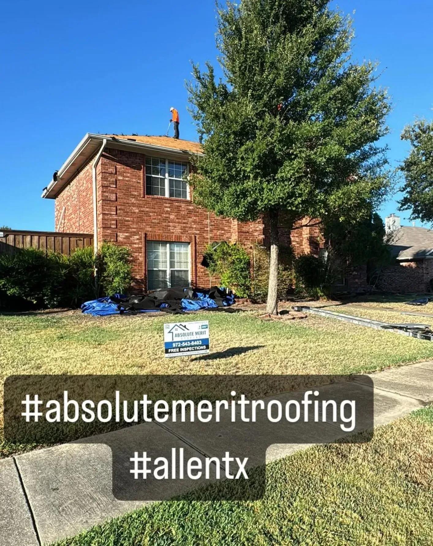 A brick house with a sign in front of it that says `` absolute meritroofing ''.
