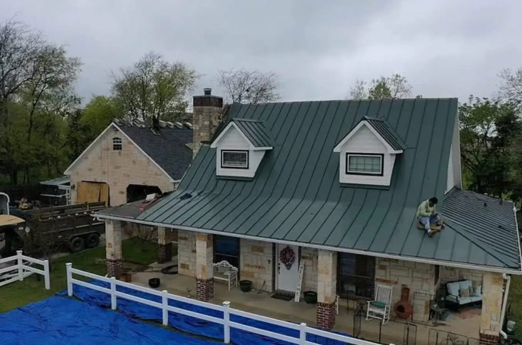 A man is working on the roof of a house.