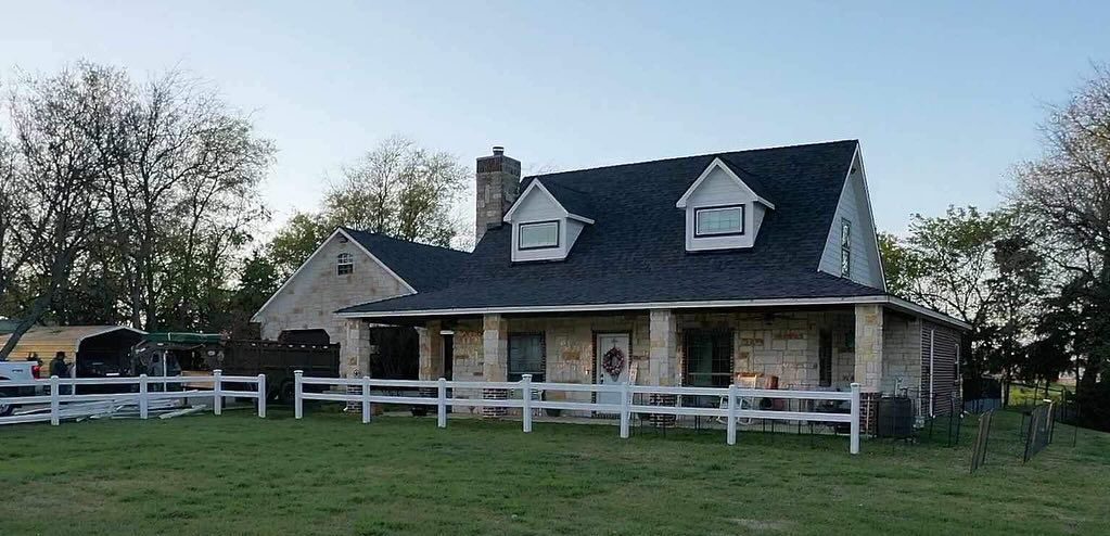 A house with a porch and a fence in front of it