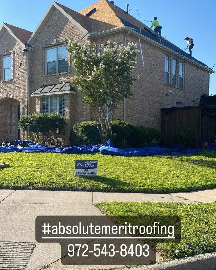 A house with a sign in front of it that says absolute meritroofing