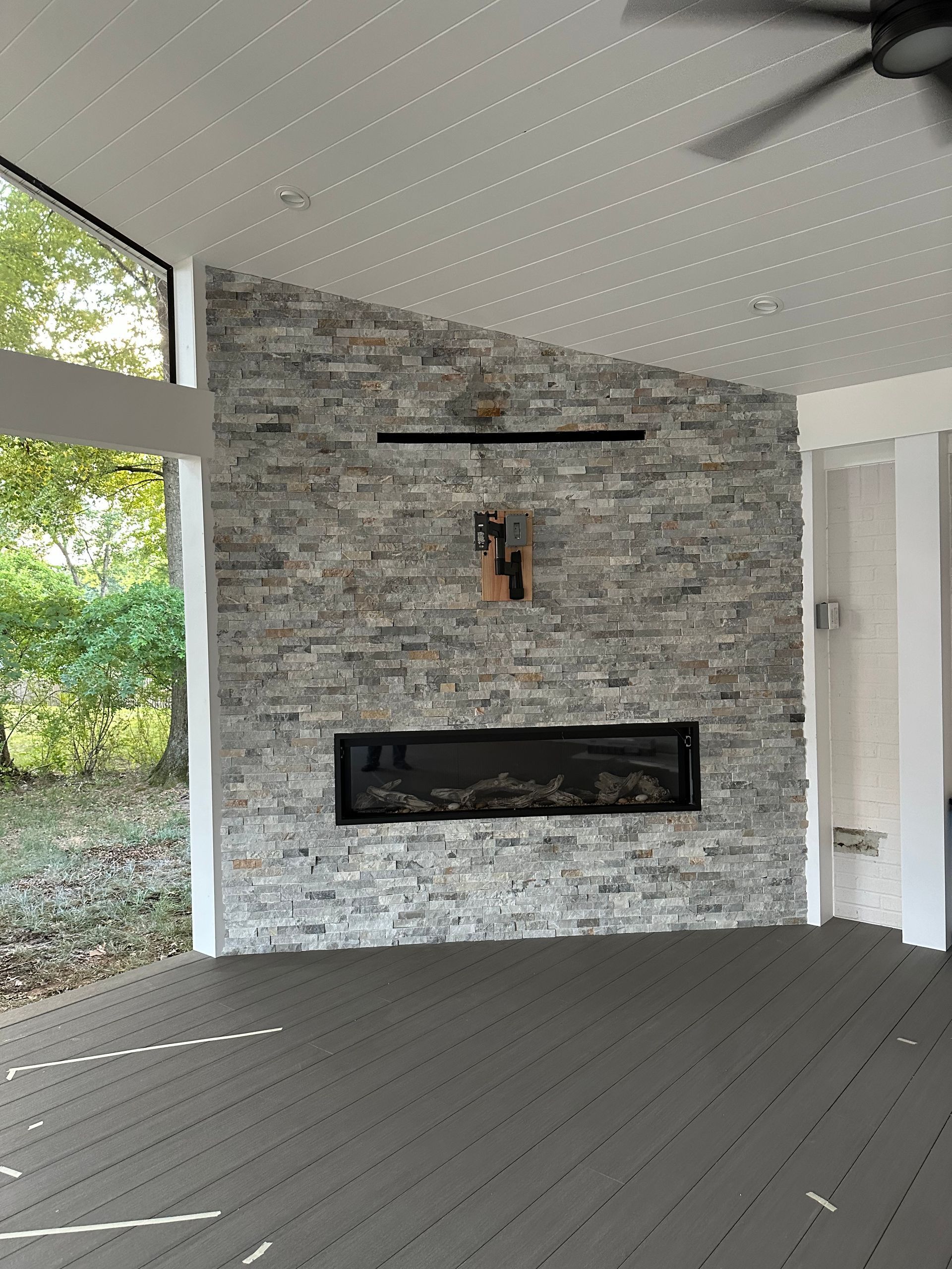 A living room with a fireplace and a ceiling fan