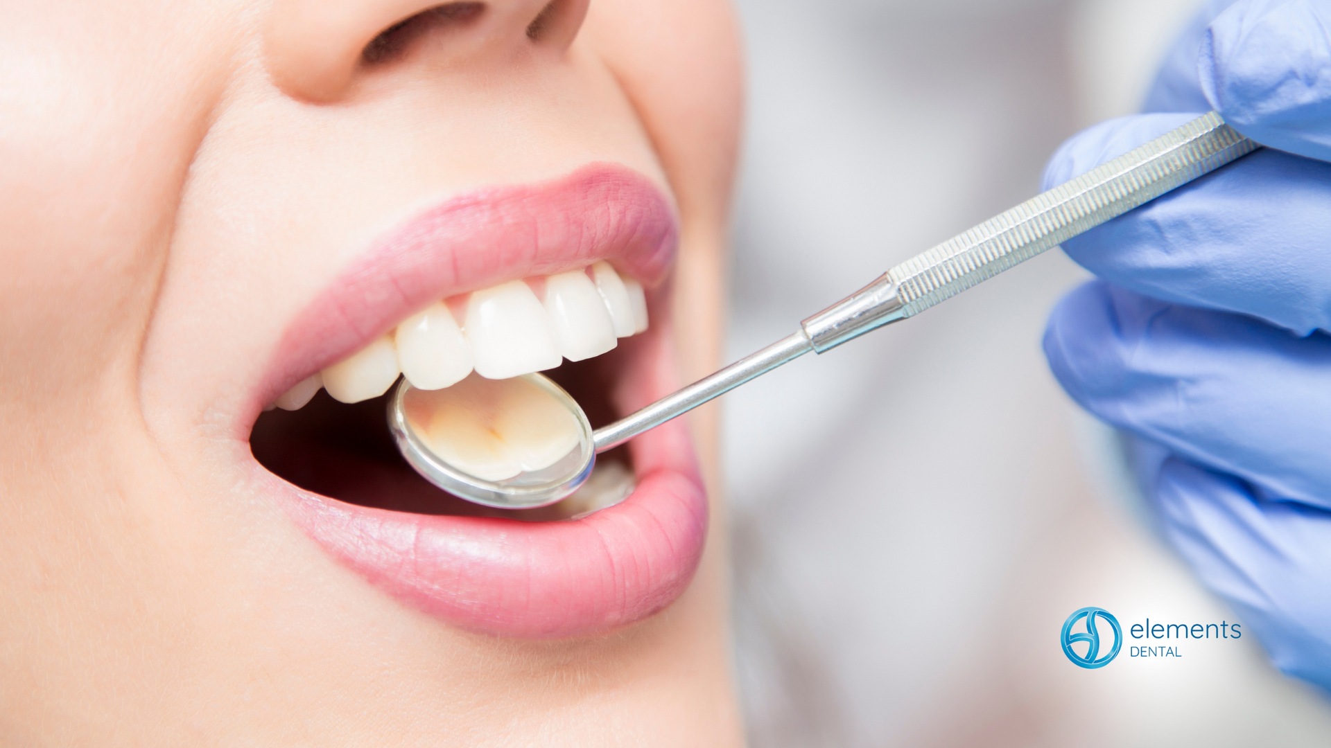 A woman is getting her teeth examined by a dentist.