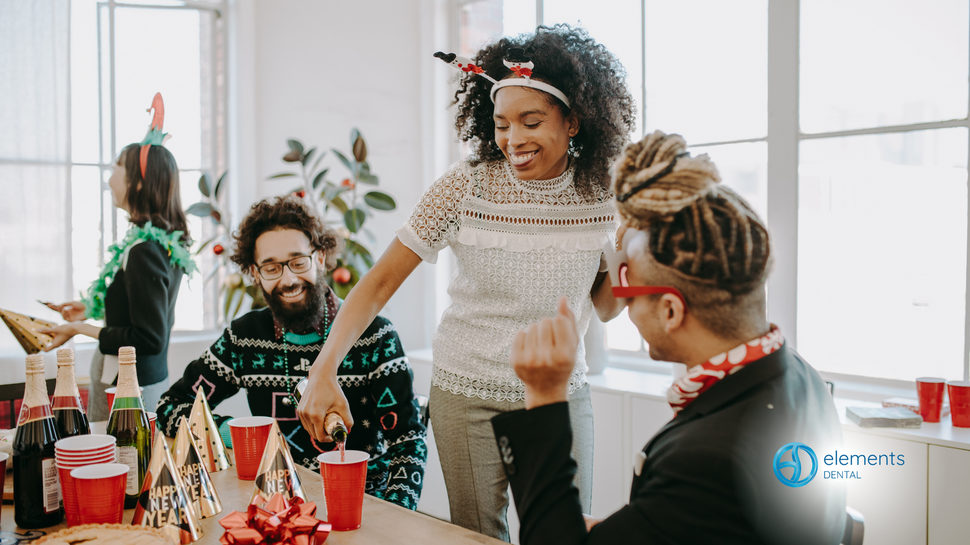 A group of people are sitting around a table at a christmas party.