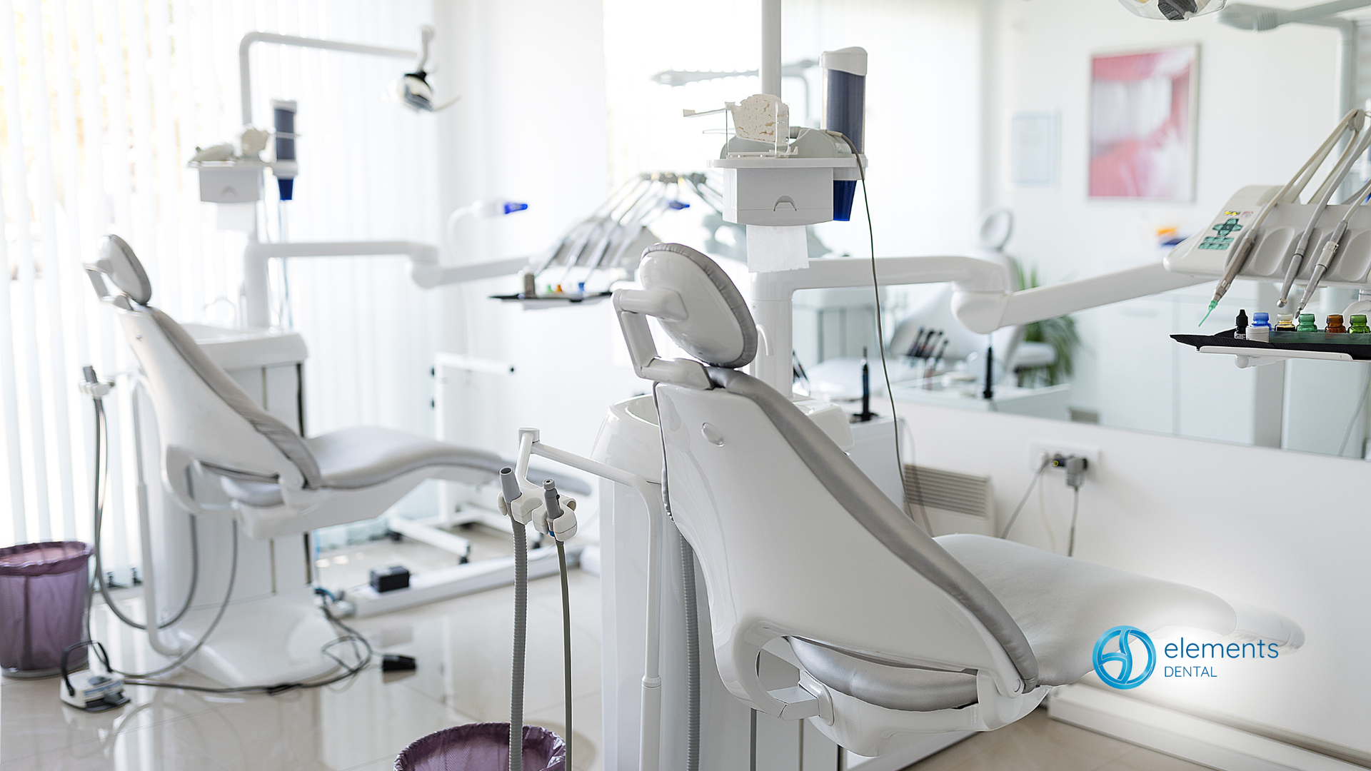 Empty dental operatory with white dental chairs and equipment.