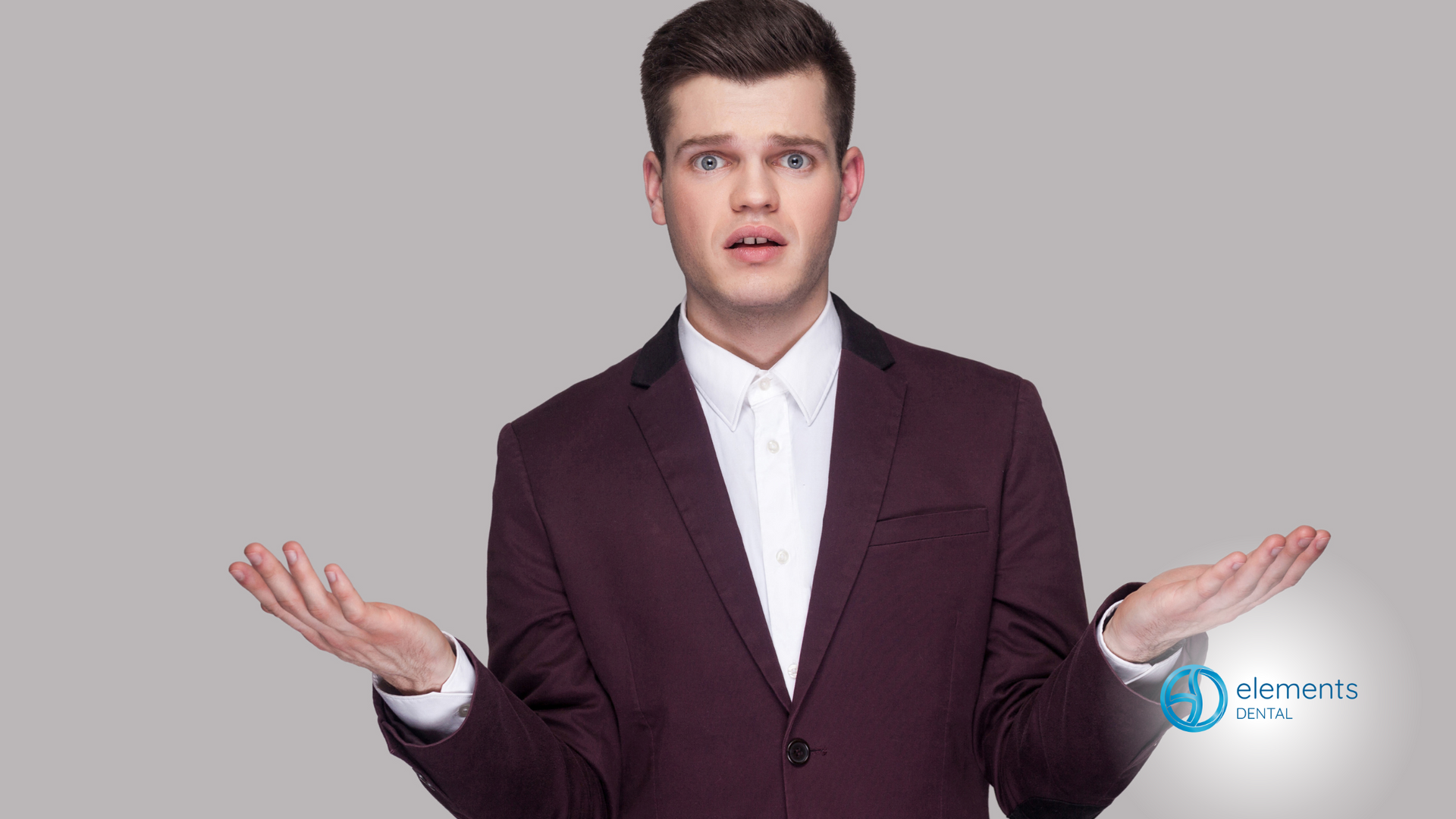 A man in a suit and tie is shrugging his shoulders.