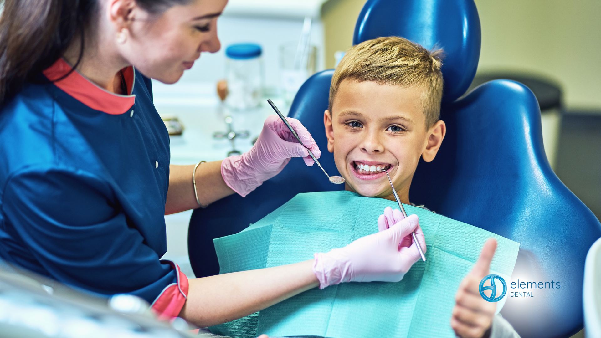 A young boy is sitting in a dental chair getting his teeth examined by a dentist.