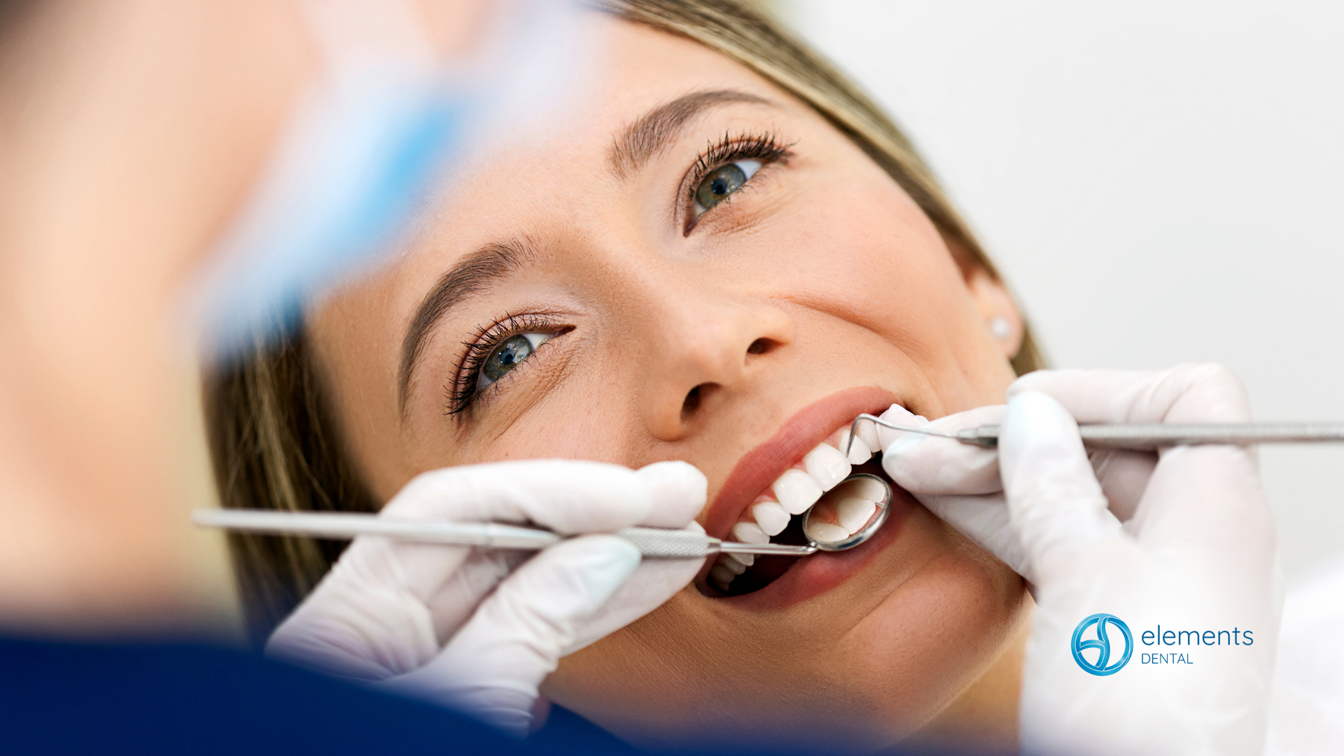 A woman is getting her teeth examined by a dentist.