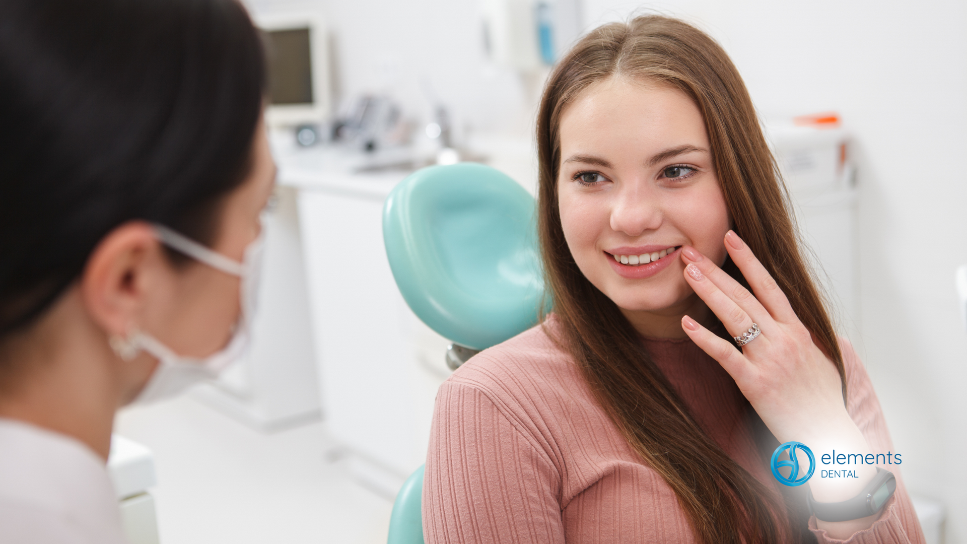 A woman is sitting in a dental chair talking to a dentist.