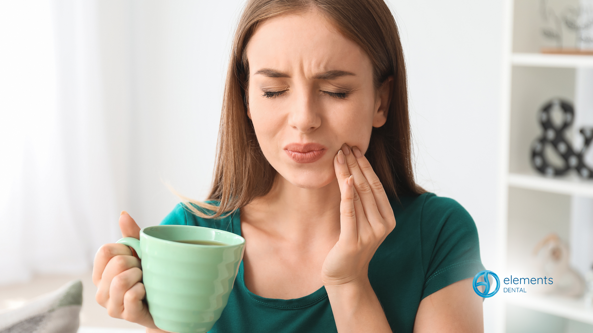 A woman is holding a cup of coffee and having a toothache.