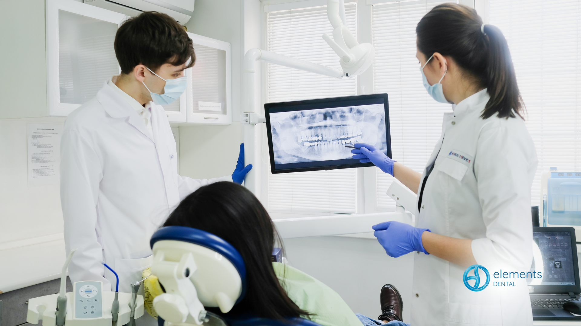 A dentist is looking at an x-ray of a patient 's teeth.