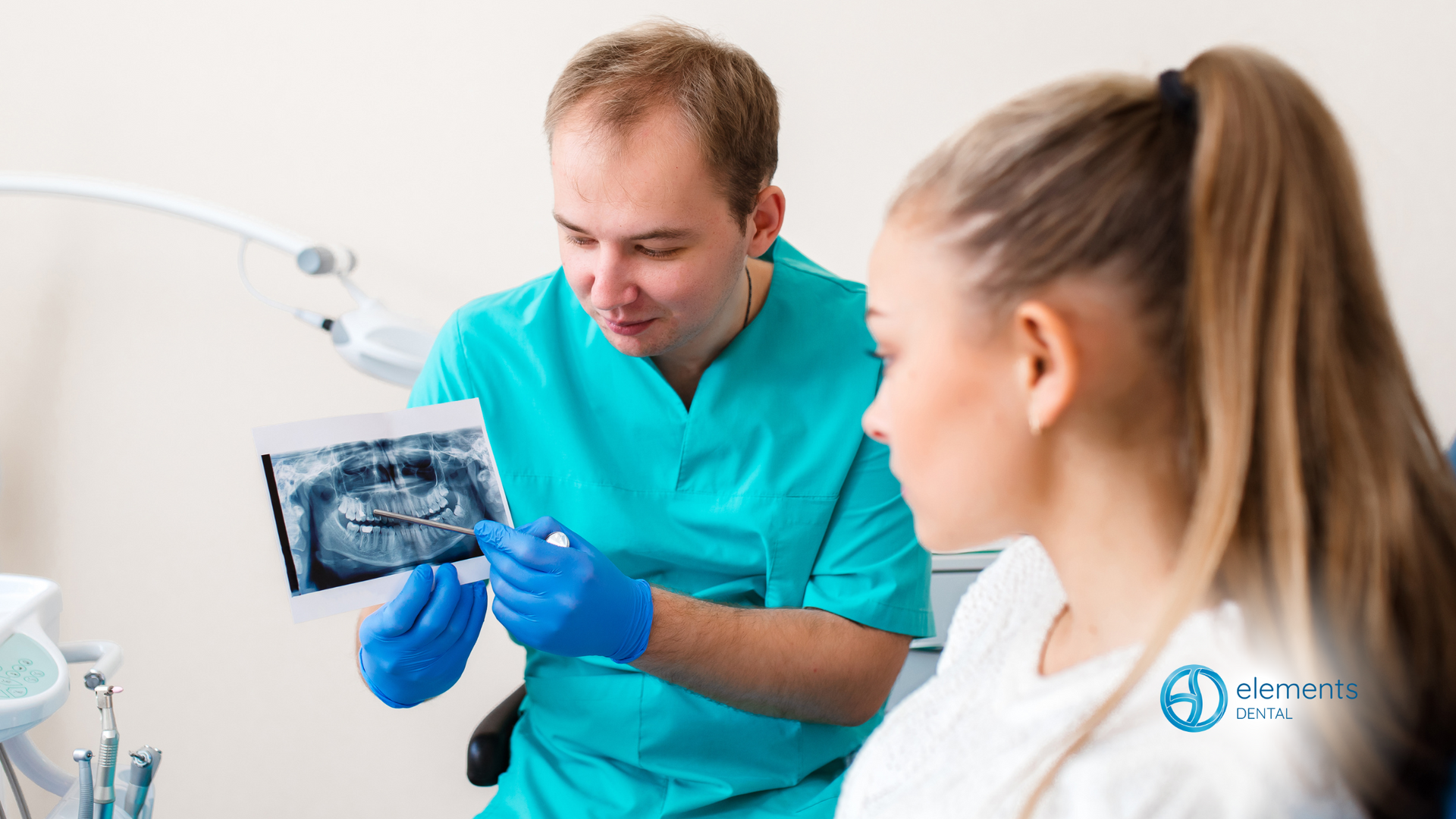 A dentist is looking at an x-ray of a woman 's teeth.