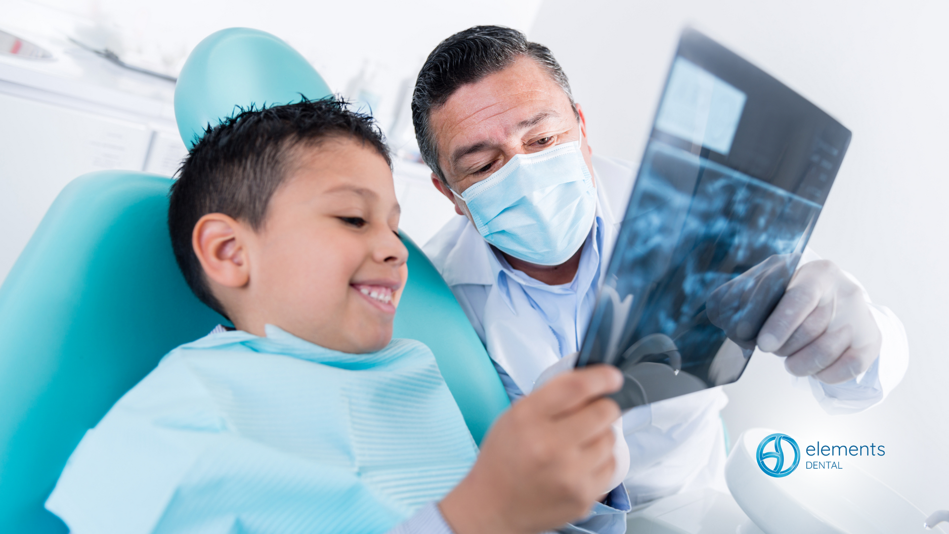 A dentist is looking at an x-ray of a young boy 's teeth.