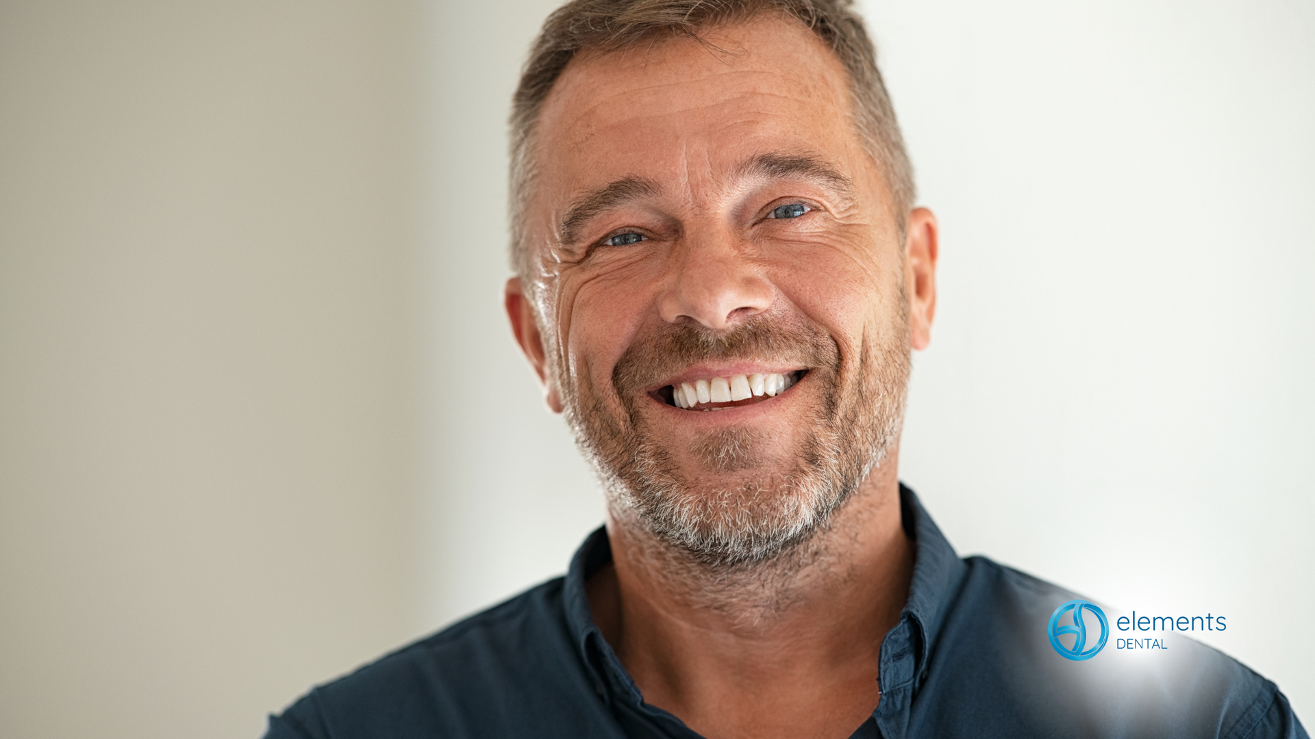 A man with a beard is smiling for the camera.