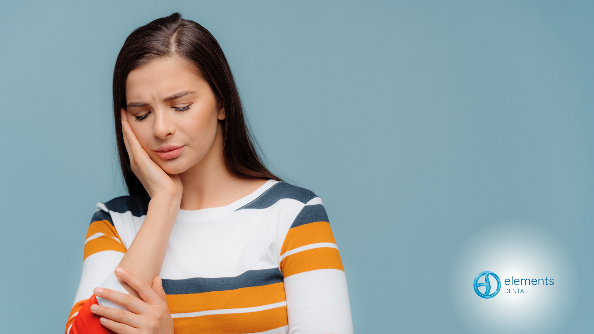 A woman is holding her hand to her face because she has a toothache.