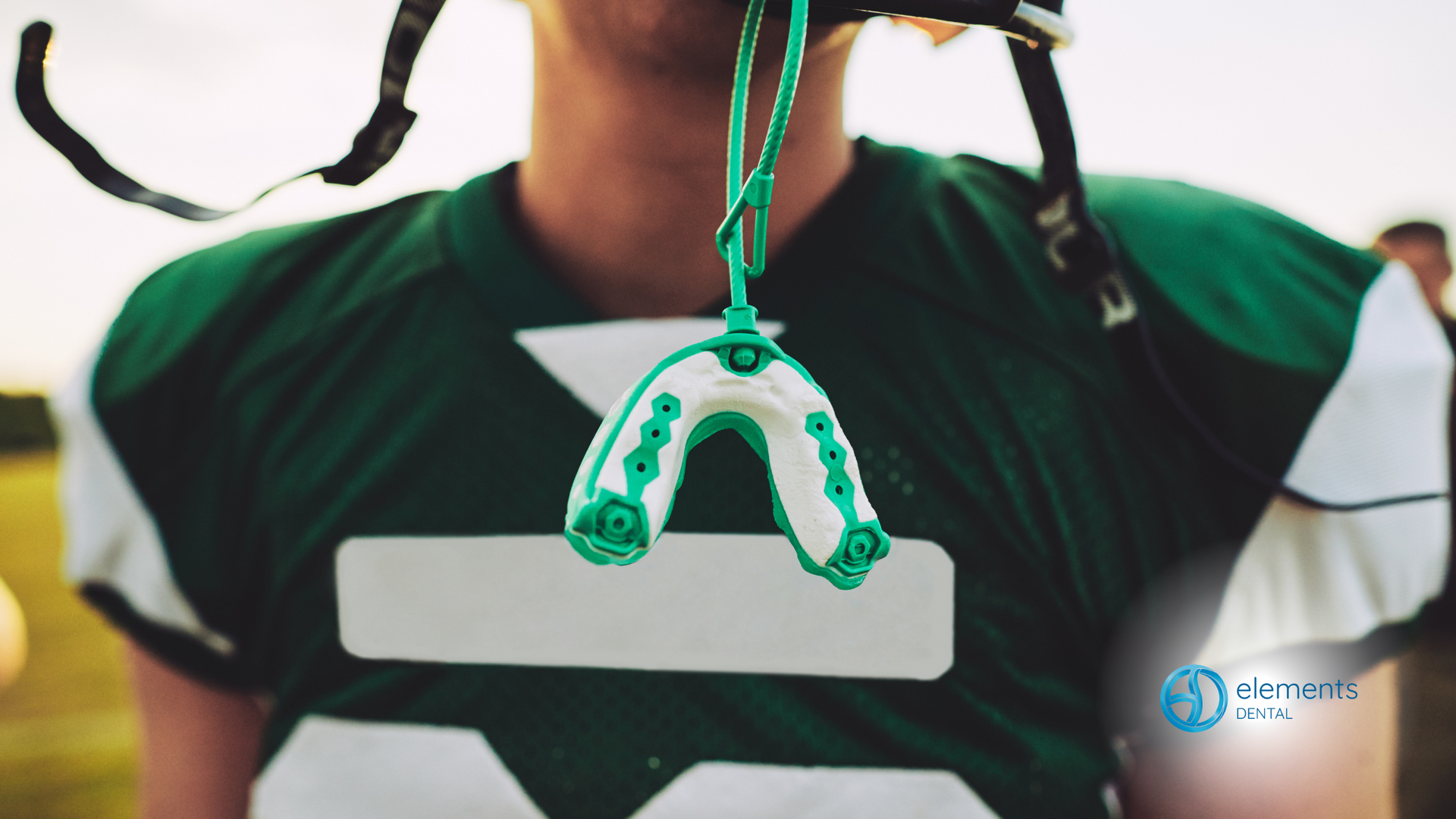 A football player with a mouth guard hanging from his helmet.