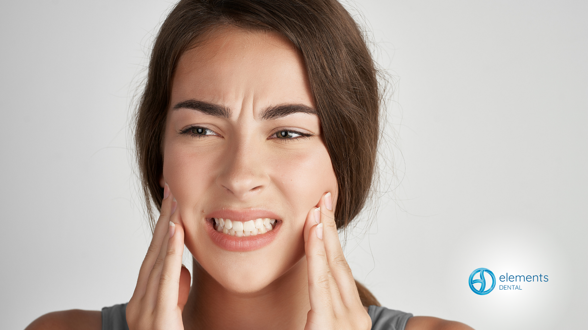 A woman is holding her face in pain because of a toothache.