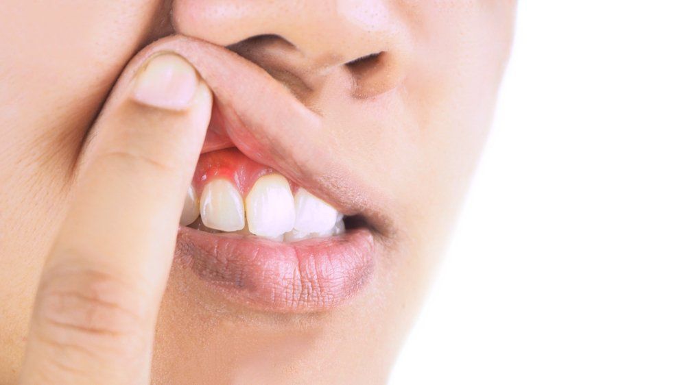 A close up of a person 's mouth with a finger in it.