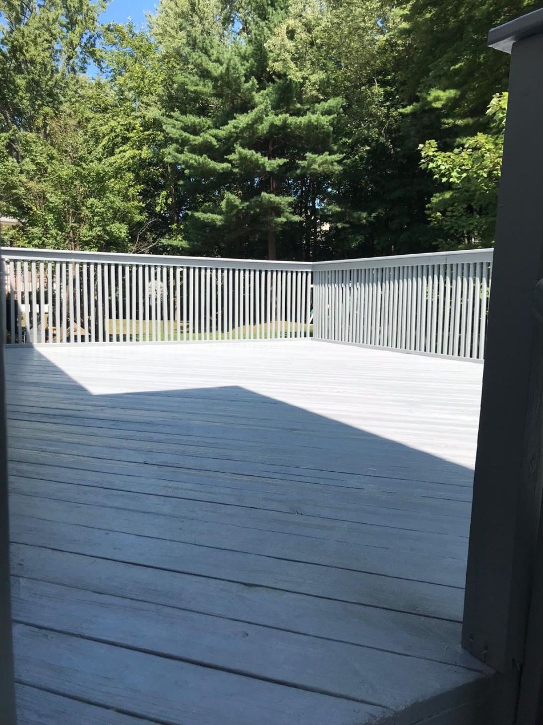 A wooden deck with a blue house in the background