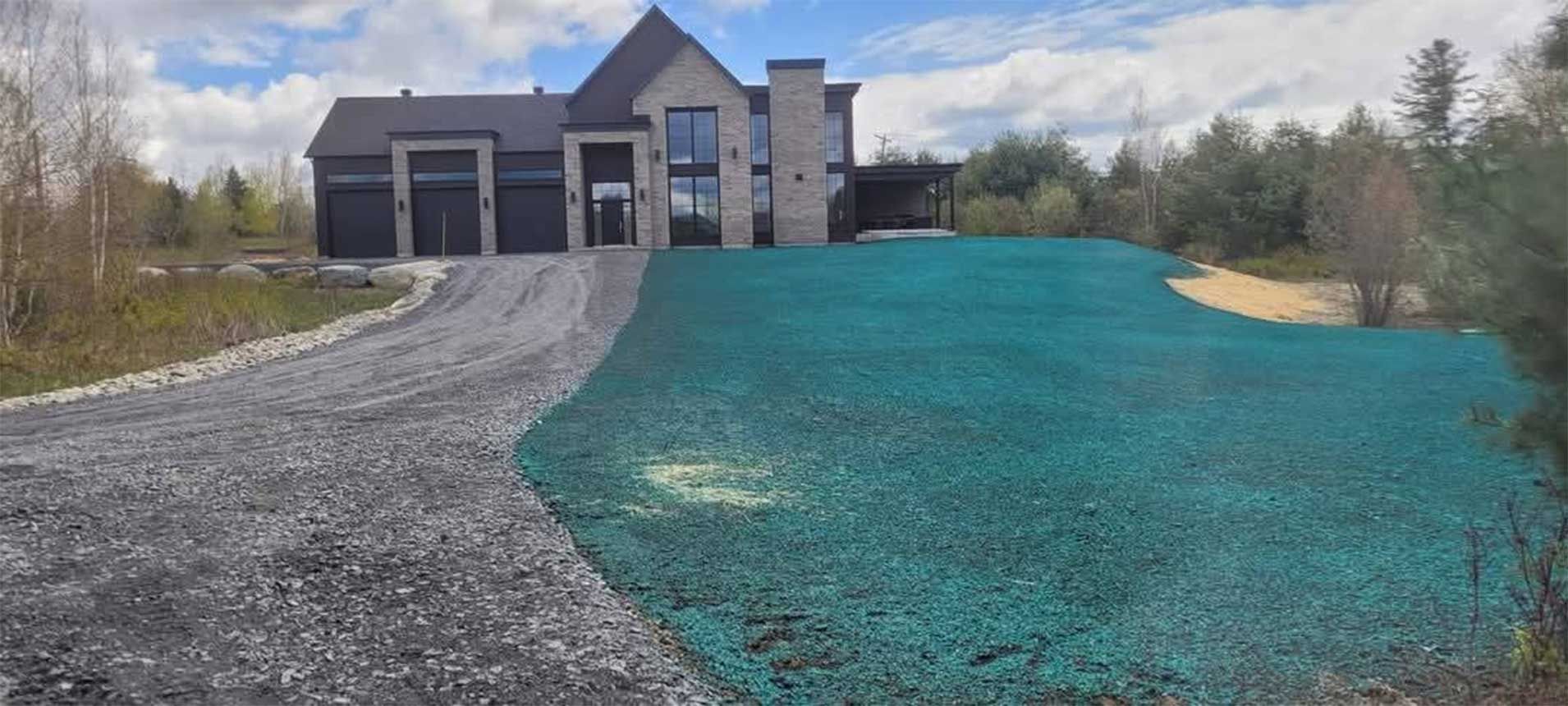 Une maison moderne avec une allée de gravier et une pelouse verdoyante.