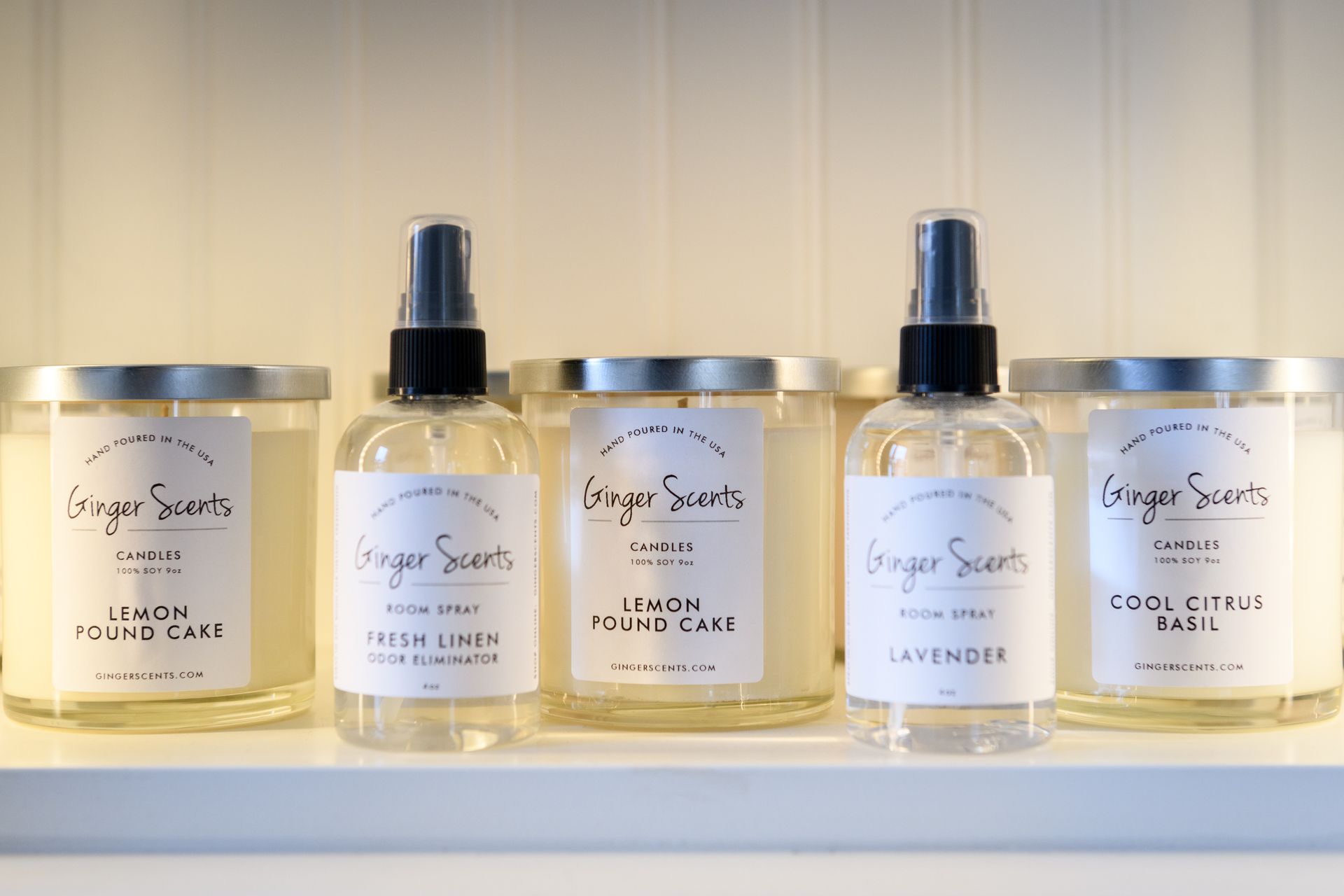 A shelf with candles and spray bottles on it.