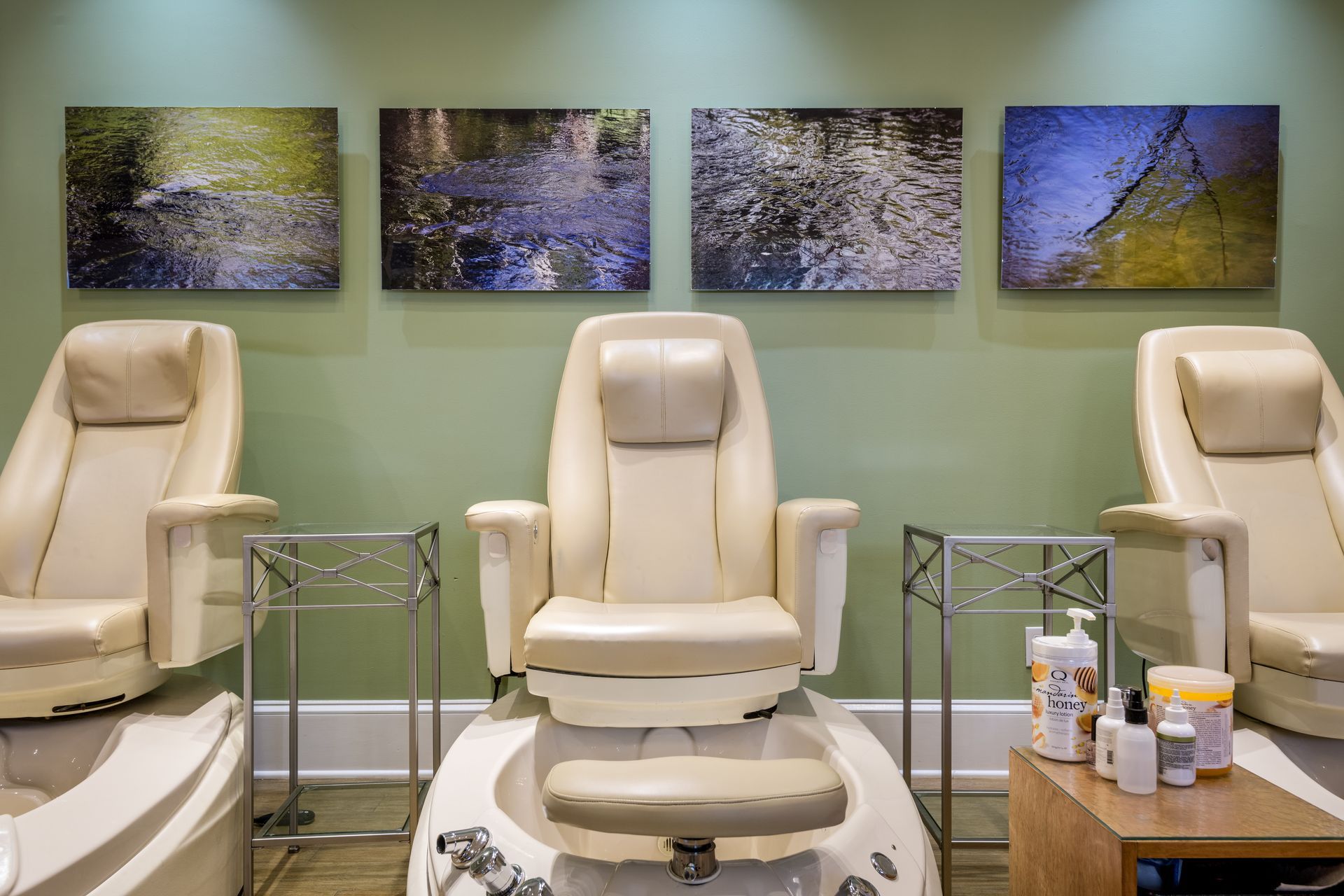 A nail salon with a lot of chairs and paintings on the wall.