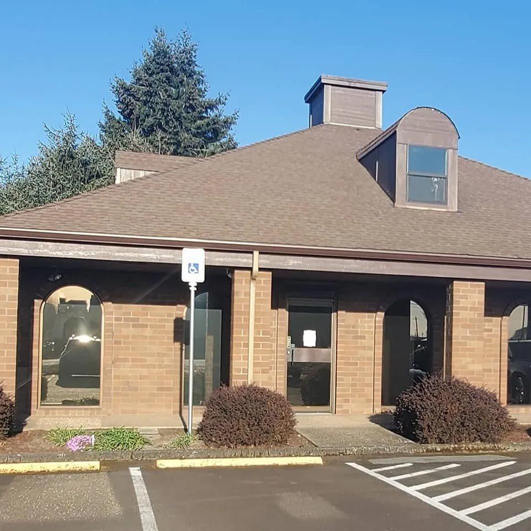 A brick building with a parking lot in front of it
