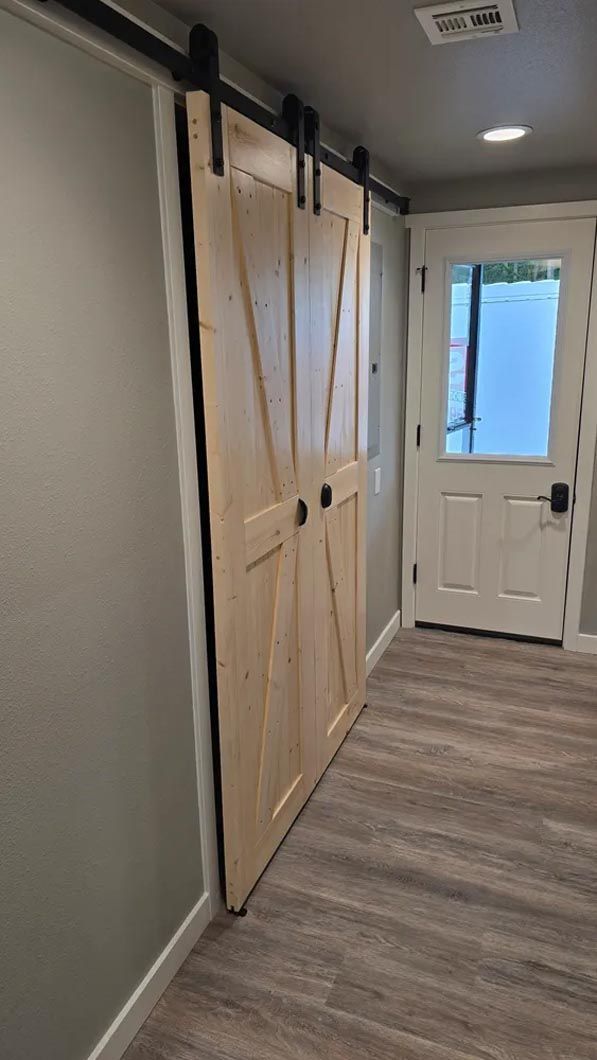 A hallway with sliding barn doors and a door.