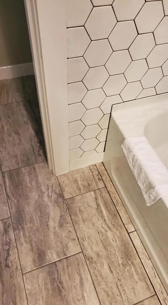 A bathroom with a bathtub and a tiled floor.