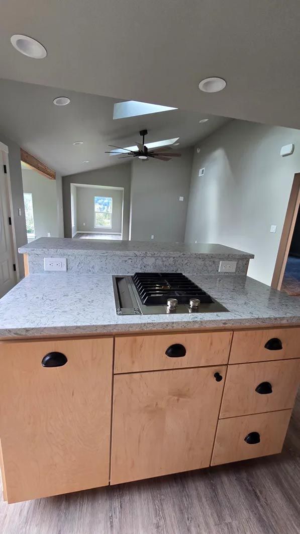 A kitchen with a stove top oven and a ceiling fan.