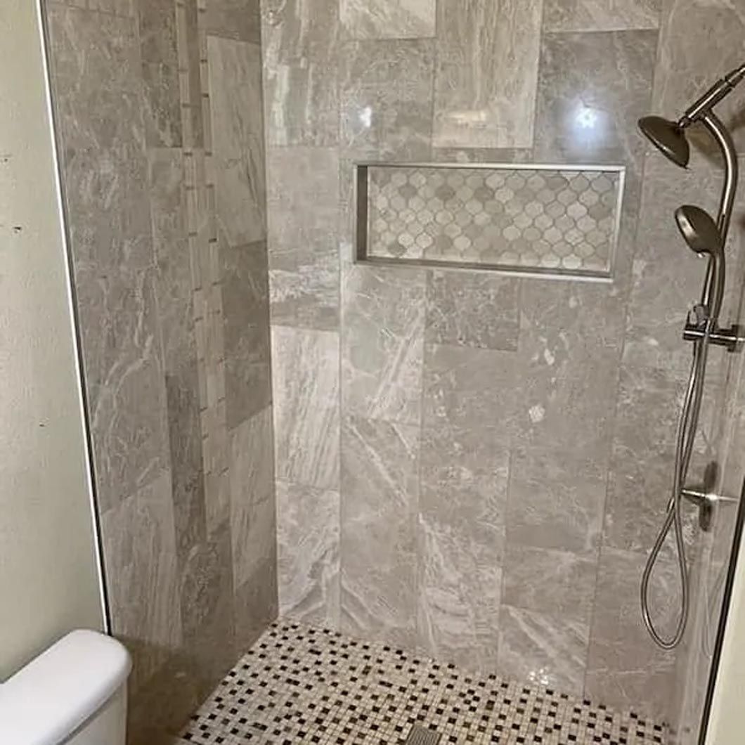 A bathroom with a shower , toilet and tiled floor.
