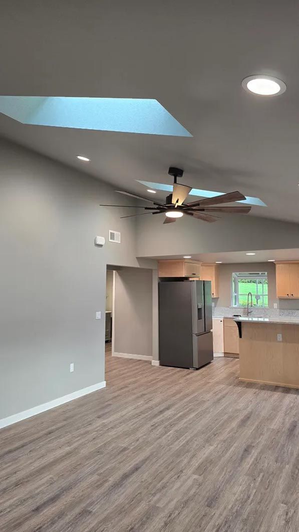 There is a ceiling fan in the living room and a skylight in the kitchen.