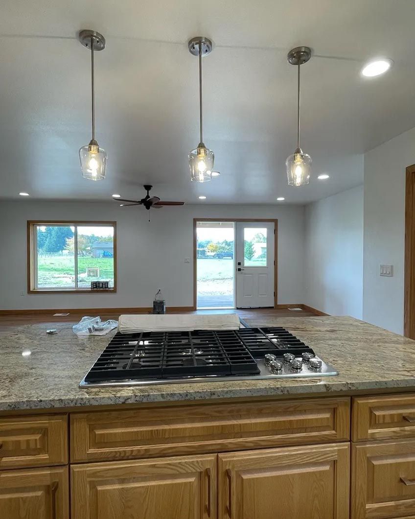 A kitchen with a stove top oven and a granite counter top.