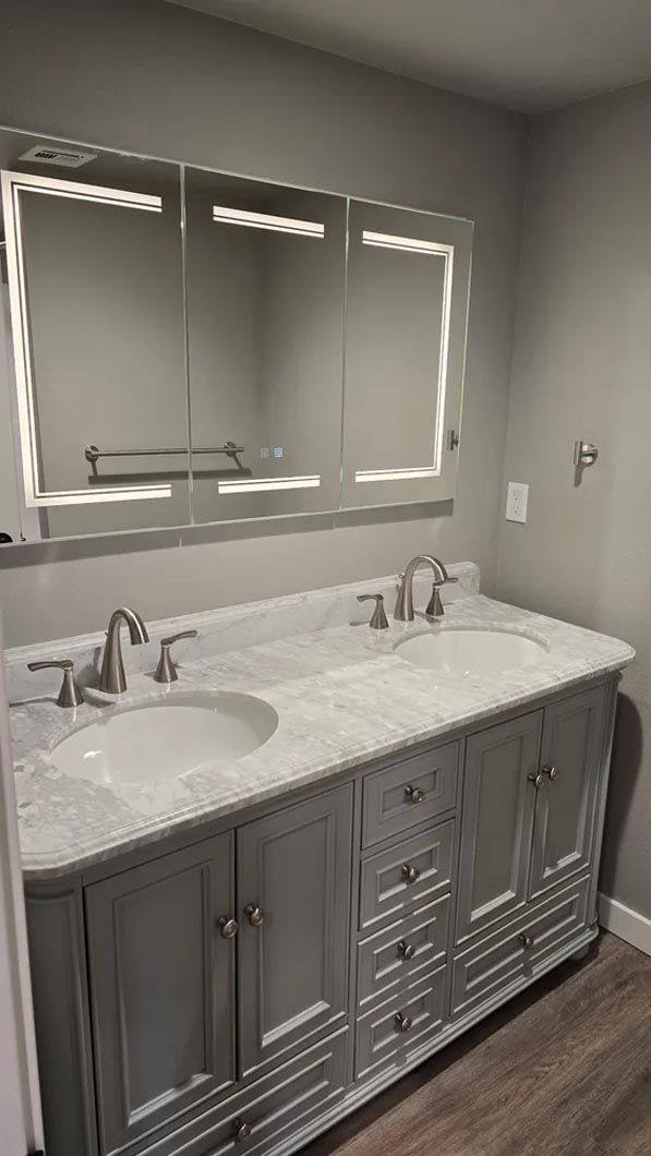A bathroom with two sinks and a large mirror.