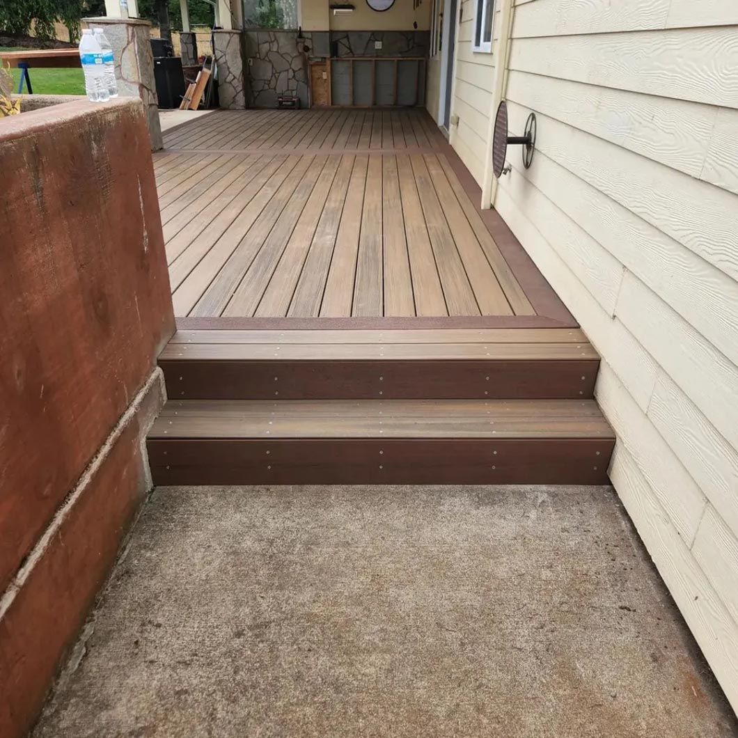 A wooden deck with stairs leading up to it next to a house.