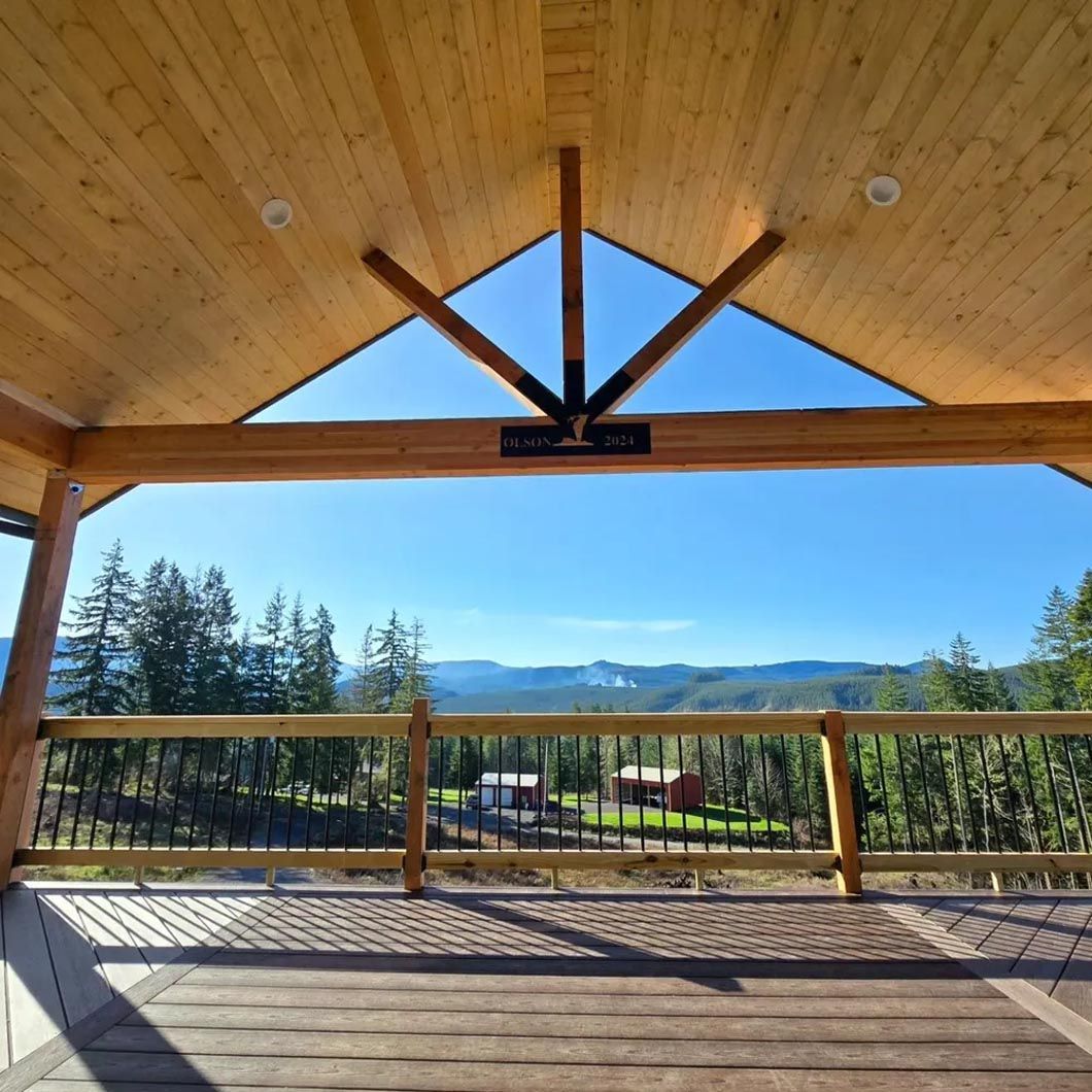 A wooden gazebo with a view of mountains and trees