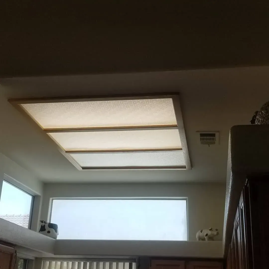 A kitchen with a ceiling light and a window