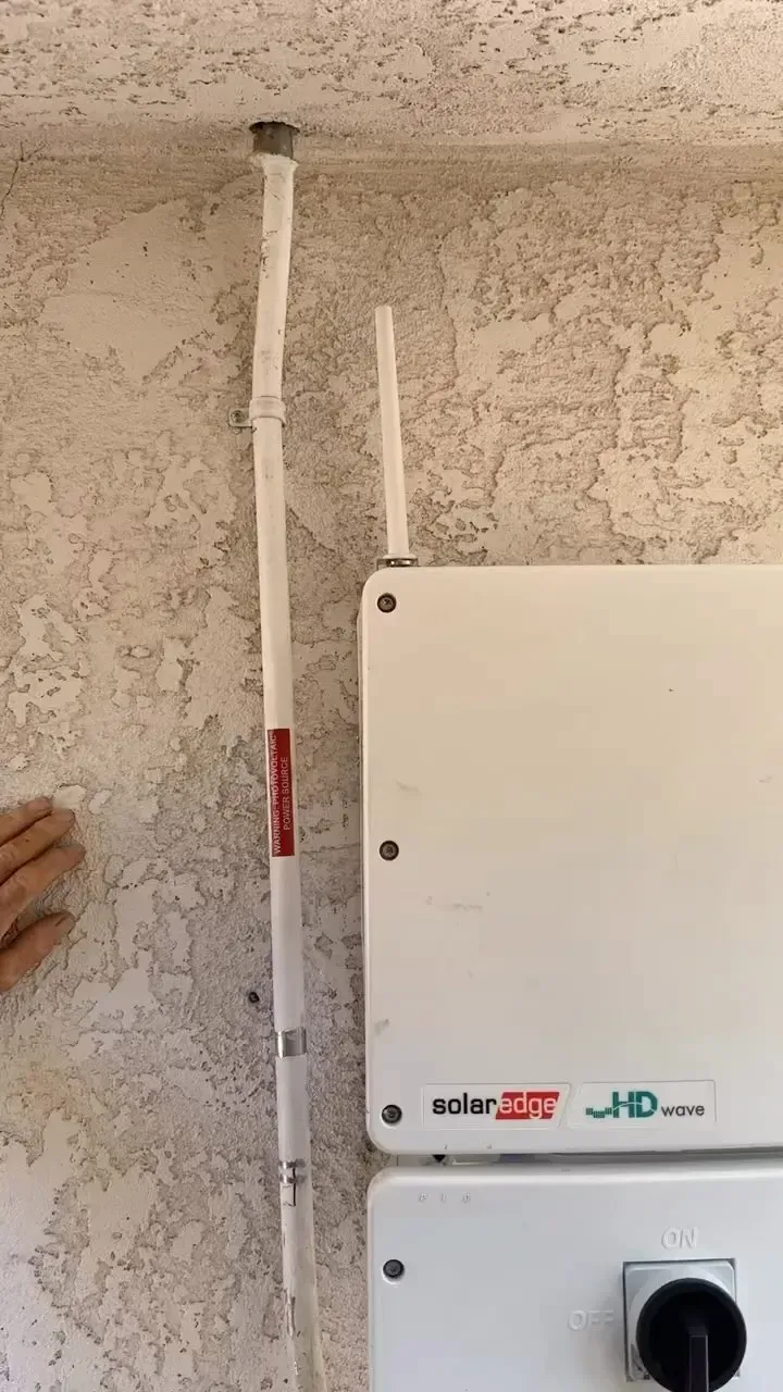 A person is installing a solar panel on a wall.